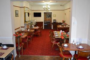 une salle à manger avec des tables et des chaises dans un restaurant dans l'établissement Park Hotel, à Ilford