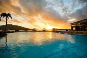 una gran piscina con puesta de sol en el fondo en Daydream Island Resort en Daydream Island