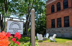 een bord voor de Sherman Inn voor een gebouw bij Sherman Inn in Ogdensburg