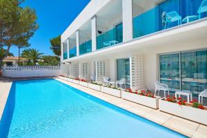 ein Pool vor einem Haus in der Unterkunft Hotel Moré in Alcúdia