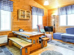 uma sala de estar com uma mesa e um sofá azul em Holiday Home Hoviranta by Interhome em Veskoniemi