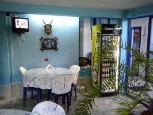 een kamer met een tafel en stoelen en een frisdrankautomaat bij Andi Hotel in Chernomorets