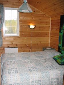 A bed or beds in a room at Mäkelän Lomatuvat Cottages