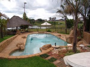 a swimming pool in a yard with a landscaping at Waterside Lodge CC in Piet Retief