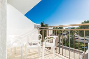 einen Balkon mit weißen Stühlen und Meerblick in der Unterkunft Hotel Moré in Alcúdia