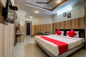 1 dormitorio con 1 cama grande con almohadas rojas en Hotel Green Valley, en Guwahati