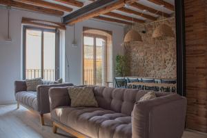 a living room with a couch and a stone wall at La Casa Del Miracle in Balaguer