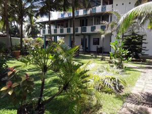 um edifício com palmeiras em frente em Karl Holiday Bungalow em Kalutara