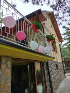 uma varanda de uma casa com cadeiras cor-de-rosa e brancas em Beautiful holiday house em Sremska Kamenica