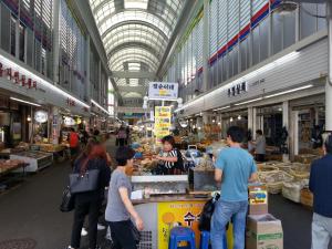 a group of people standing around a market in a building at Gloryinn in Seoul