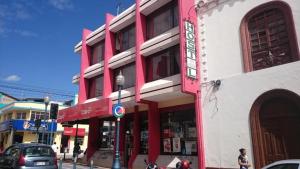 um edifício vermelho e branco numa rua da cidade em Flying Donkey em Otavalo