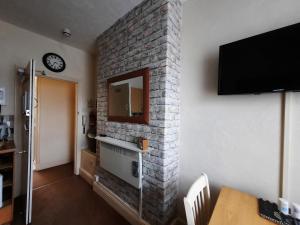 a living room with a brick wall with a mirror at Morwenna Luxury Holiday Apartments in Llandudno