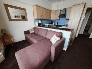 a living room with a couch and a kitchen at Morwenna Luxury Holiday Apartments in Llandudno