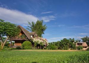 una casa con dei fiori in un campo di Cozycomo Chiang Dao - Wiang Mek a Chiang Dao