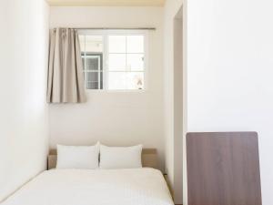 a bedroom with a bed and a window at Bluebird Hotel in Fujikawaguchiko