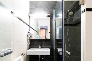 a bathroom with a sink and a shower at Bastion Hotel Groningen in Groningen