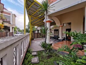 - un balcon d'une maison avec un palmier dans l'établissement Nariska Suite Homestay, à Yogyakarta