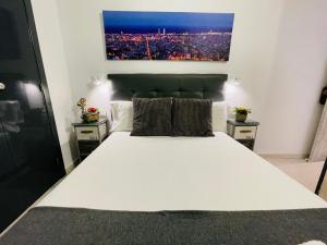 ein Schlafzimmer mit einem großen weißen Bett mit zwei Nachttischen in der Unterkunft Hostal Lleida in Barcelona