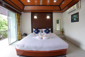 - une chambre avec un grand lit orné d'une fleur dans l'établissement Vivi Boutique Room Hotel SHA Plus, à Rawai Beach