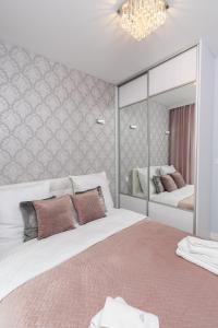 a bedroom with two beds and a large mirror at Angel Apartments 2 in Kraków