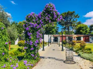 um jardim com flores roxas num caminho em Erettz Dafna Travel Hotel em Dafna