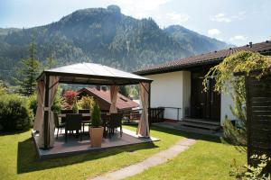 um gazebo com uma mesa e cadeiras num quintal em Chalet Sabrina mit Außenpool im Sommer em Kaprun