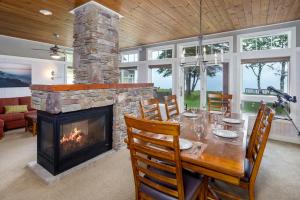 comedor con mesa y chimenea en Larsmont Cottages en Two Harbors