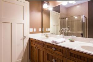 baño con lavabo y espejo grande en Larsmont Cottages en Two Harbors