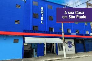 a blue building with a sign in front of it at LM Hotel in Sao Paulo