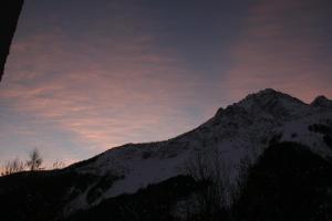 uma montanha coberta de neve com um céu nublado em Dolomiti house em Cibiana