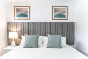 a bedroom with a large bed with blue and white pillows at Rumba Beach Resort in Caloundra