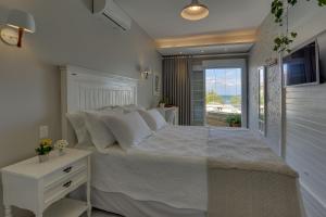 a bedroom with a large white bed and a window at Solar Beach Hotel in Florianópolis