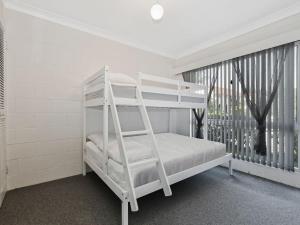 a white bunk bed in a white room with a window at Blueys Beach Villa Manyana 11 in Blueys Beach