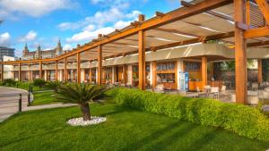 ein großes Gebäude mit einer Palme im Hof in der Unterkunft Baia Lara Hotel in Lara