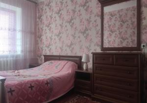 a bedroom with a bed and a dresser and a window at 2-х комнатная квартира in Korostenʼ