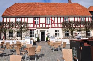 um grande edifício vermelho e branco com cadeiras e mesas em Hotel Ringkøbing em Ringkøbing