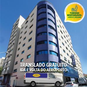 uma carrinha estacionada em frente a um edifício alto em Hotel Domani em Guarulhos