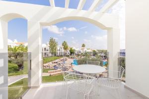 einen Balkon mit einem Tisch und Stühlen sowie Poolblick in der Unterkunft MarSenses Paradise Club in Cala'n Bosch