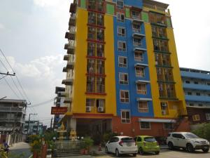 un edificio colorido con coches estacionados frente a él en ฐิติกร แกรนด์วิว en Thanya Buri