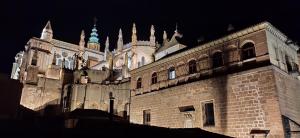 un grande edificio con una torre dell'orologio sopra di La Posada de Manolo a Toledo