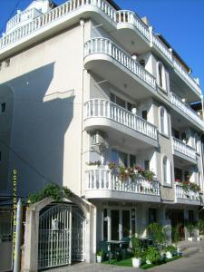 un grande edificio bianco con balconi e tavolo di Hotel Pasians a Pomorie