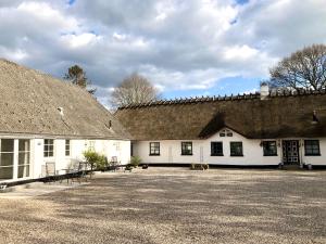 ein großes weißes Gebäude mit einem Dach in der Unterkunft Kroghøjgård in Middelfart