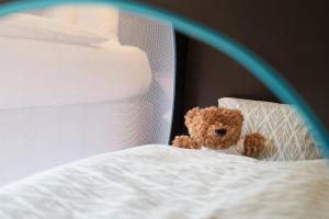 un osito de peluche sentado encima de una cama en Sorell Hotel St. Peter en Zúrich