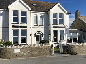 una casa con una valla de piedra delante de ella en Bosayne Guest House, en Tintagel