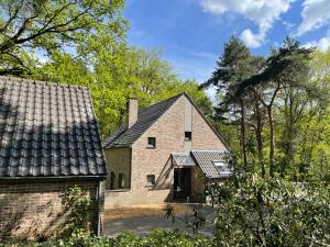 een oud stenen huis met een dak bij Sterrenheide in Heusden - Zolder