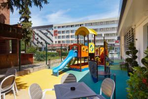 um parque infantil com escorrega e cadeiras e um edifício em Diamond Hotel - All Inclusive em Sunny Beach