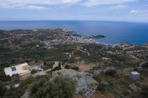 eine Luftansicht einer Stadt auf einem Hügel in der Nähe des Ozeans in der Unterkunft Olenia Residence in Agia Pelagia