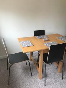 une table en bois avec quatre chaises dans une chambre dans l'établissement 8 Pickering Road, à Telford