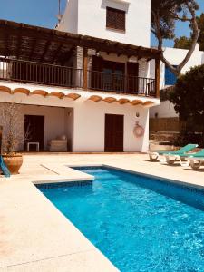 uma villa com piscina em frente a uma casa em Villa Imperial em Cala d´Or