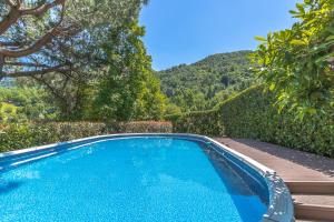 una piscina azul con una montaña en el fondo en Villa La Perla - Bellagio en Bellagio